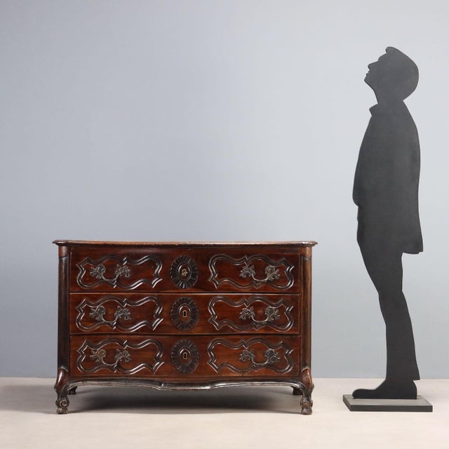 A Baroque walnut chest of drawers from France dating back to the early 18th century, featuring a curved front composed of...