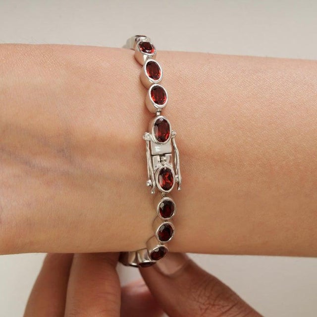 A refined garnet bezel set tennis bracelet in 925 sterling silver, offering a timeless interplay of structure and color....