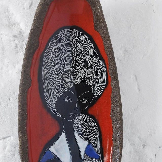 Ceramic piece decorated using the sgraffito technique, depicting a young woman in black, blue, yellow, and green enamel on...