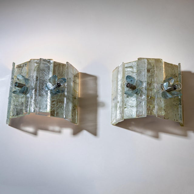 Pair of wall sconces composed of rectangular glass panels arranged in a fan-shaped semicircular formation. The glass...