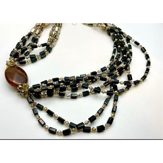 Multi-strand seven strand necklace, pairing jet-black bar/rectangular tube beads, mirror-finish gunmetal glass rectangles,...