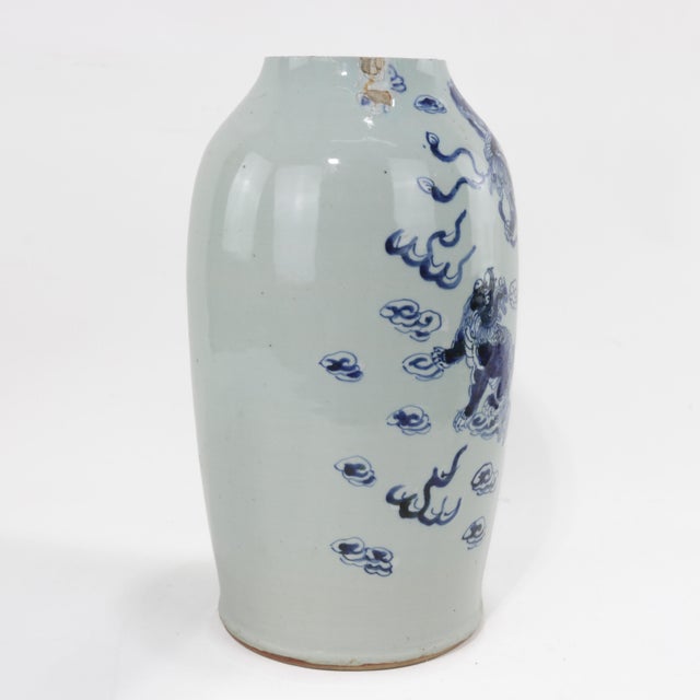 This striking Chinese blue and white porcelain vase showcases a dynamic design of Foo Lions (Foo Dogs) surrounded by...