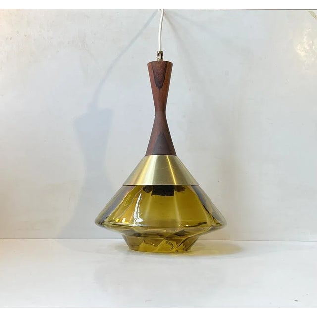 A diablo shaped hanging light with pickle/olive green main glass shade and a top in solid dark hardwood. Manufactured by...
