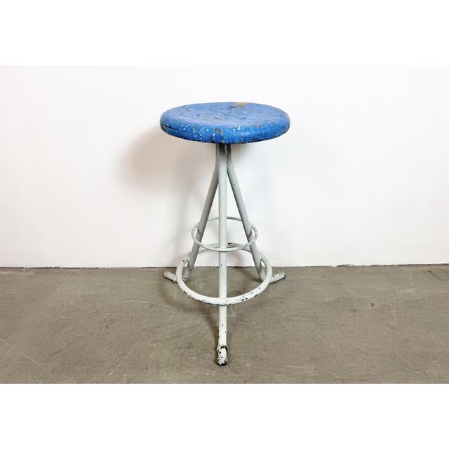 Vintage Industrial factory stool made in former Czechoslovakia during the 1960s It features a blue painted wooden seat and...