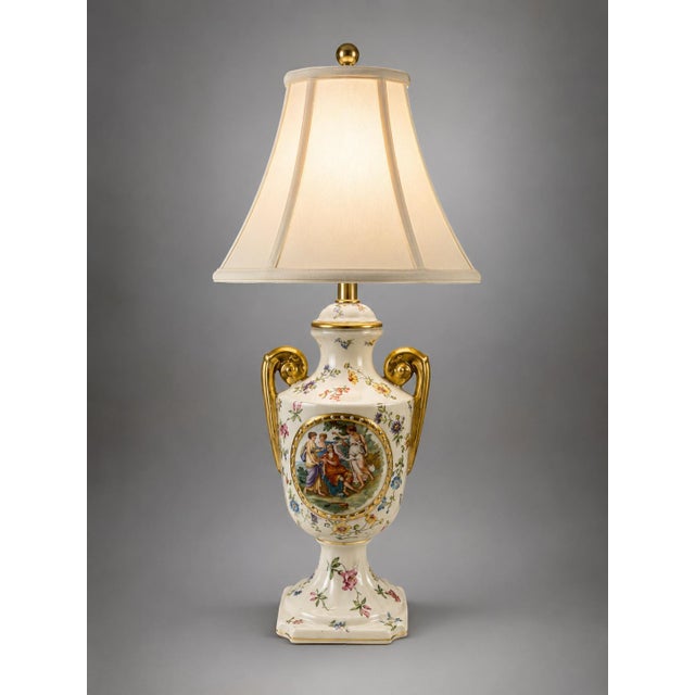 Elegant vintage Victorian-style table lamp featuring an ornate cream and white urn-form body with gold-tone scrolling...