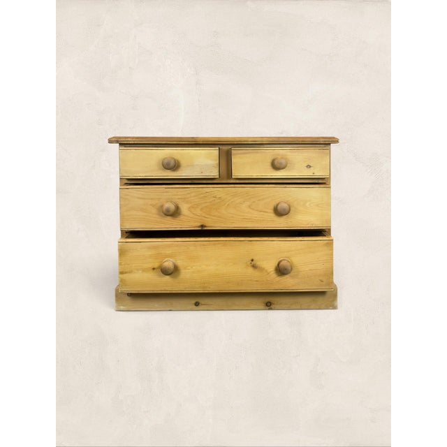A charming antique English pine chest of drawers dating to circa 1900. Crafted from solid pine, this piece features a...