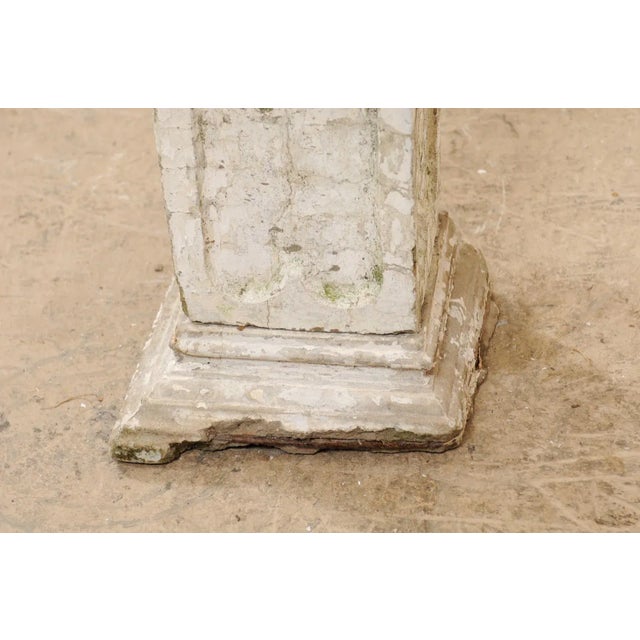 A tall French garden sculpture of a winged boy angel from the early 20th century. This antique statue from France sweetly...