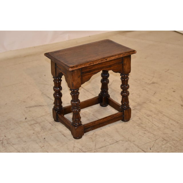 19th century oak joint stool from England. The top has a beveled edge, following down to scalloped aprons with routed...