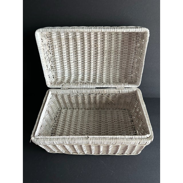 White wicker basket with hinged lid. Great for storage. Approximately 12” x 7” x 7”.