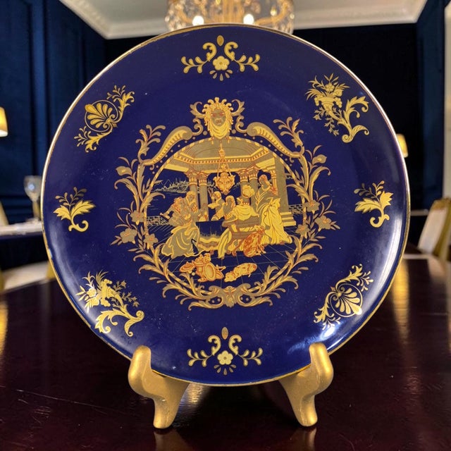 The product is a vintage Asian Chinoiserie cobalt blue gilded figural scene decorative plate. This collector plate...