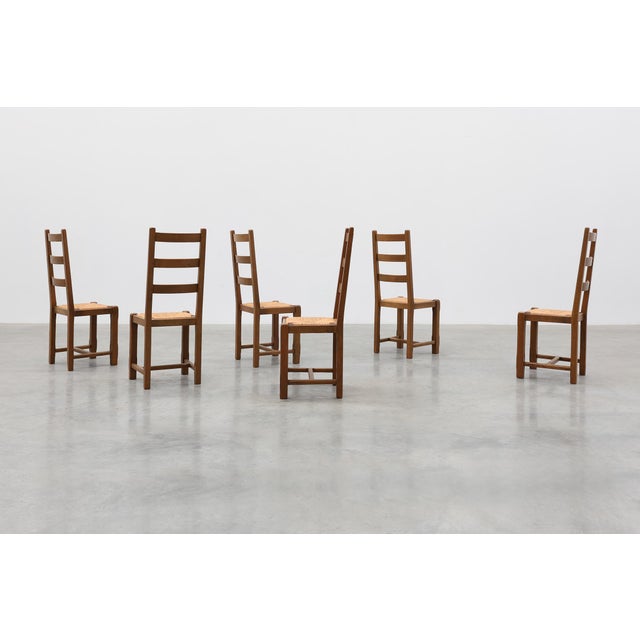 A charming set of six French rustic dining chairs crafted in solid oak, distinguished by their timeless ladder-back design...