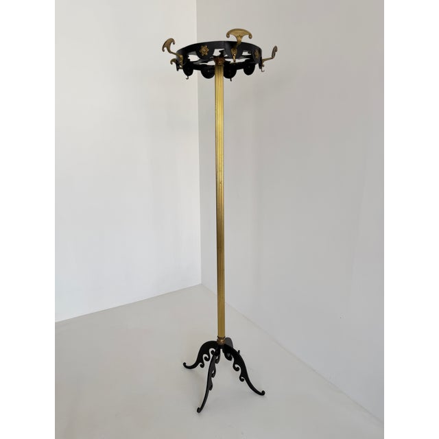 An elegant Italian coat rack dating from the 1950s, beautifully crafted from warm aged brass combined with black lacquered...