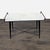This rectangular console table features a smooth marble tabletop in white with raised black metal handles on the sides,...