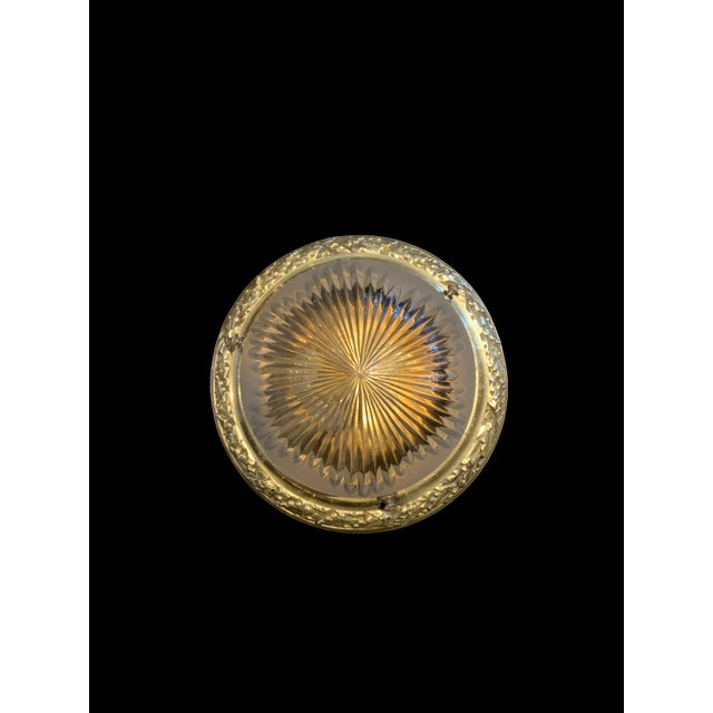 A circa 1920's English neoclassic style brass flush-mounted light fixture with etched glass globe and one light socket....