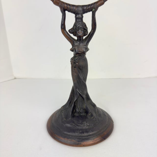Vintage Art Nouveau figural vanity mirror made of cast spelter and featuring a flowing‑gowned lady lifting an oval mirror...