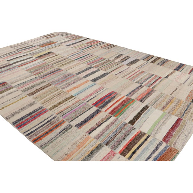Handwoven in wool, this 10x14 oversized modern Kilim rug from Rug & Kilim’s Patchwork Kilim rug collection marries...