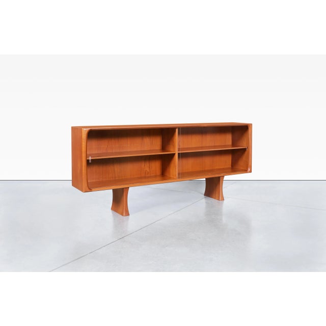 Danish modern teak credenza / bookcase designed by Bernhard Pedersen in Denmark, circa 1960s. Showcasing the refined...
