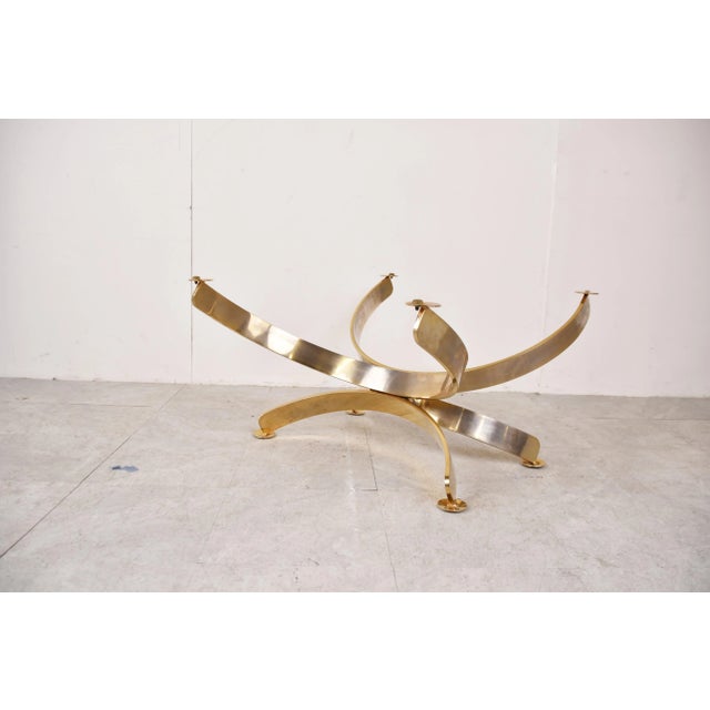 Vintage coffee table with a sculptural brass base and a smoked glass top. Beautiful timeless design. Good condition with...