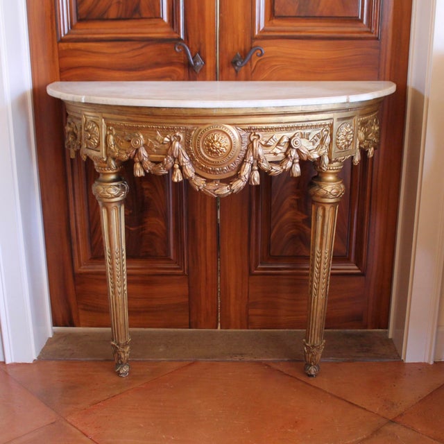 A stately Italian Neoclassical demilune console table with a wonderful carved apron centered on a bold rosette medallion...