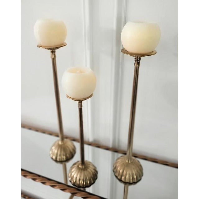 Beautiful set of three vintage brass candlesticks featuring an elegant scalloped design and a clean, polished finish....