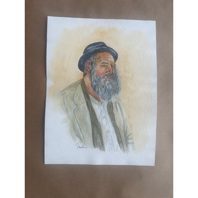 A character-rich portrait of a bearded man in a brimmed hat, painted with delicate washes and subtle tonal layering. The...