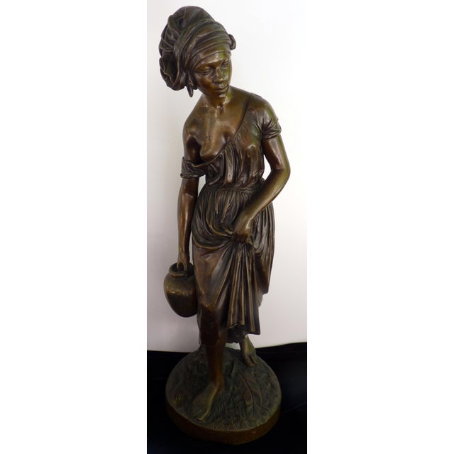 This exceptional 19th-century French Orientalist bronze sculpture depicts a Nubian water carrier in a moment of graceful...
