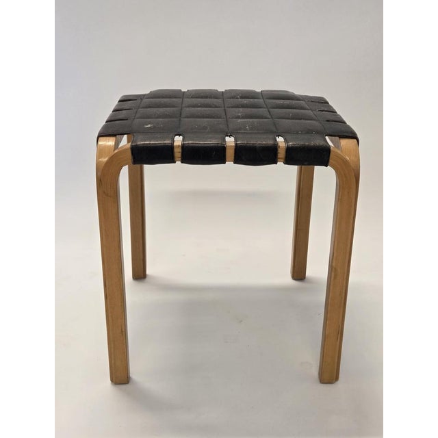 Artek Y61 stool, birch with original black leather upholstery. The stool is from the 1950s. Designer Alvar Aalto. In good...