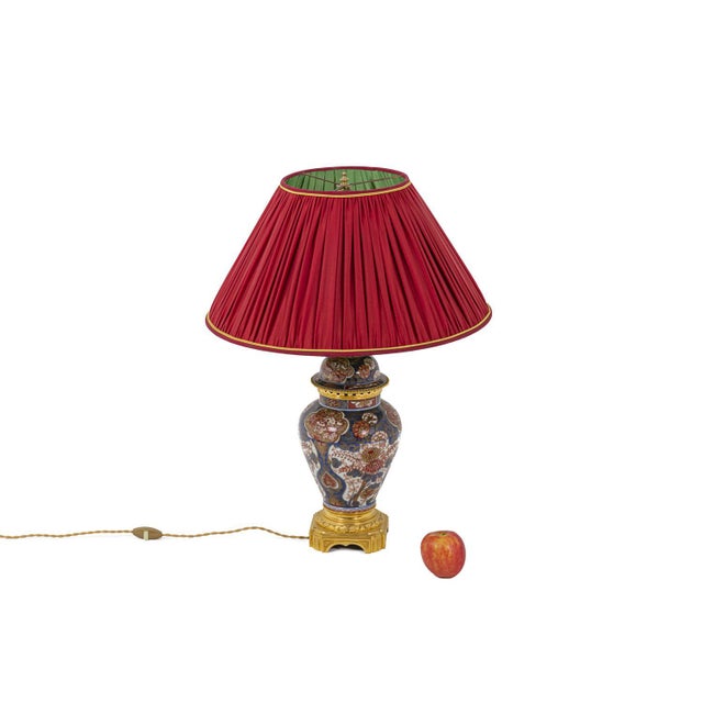 Baluster shaped lamp with imari decor in porcelain and gilt bronze. Body adorned with red flower motifs on a white and...