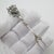 This vintage silver tableware object depicts a cocktail mini fork with a grapevine and grape cluster relief handle,...