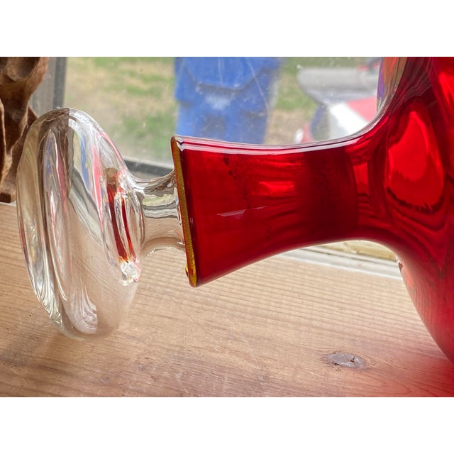 Hand blown Ruby Red Flask with a Crystal Clear Stopper Delicate, Amberina rim on flask. Condition: I have not been able to...