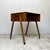 A compact mid century teak cabinet on castors, with an open storage compartment and distinctive splayed legs. The...