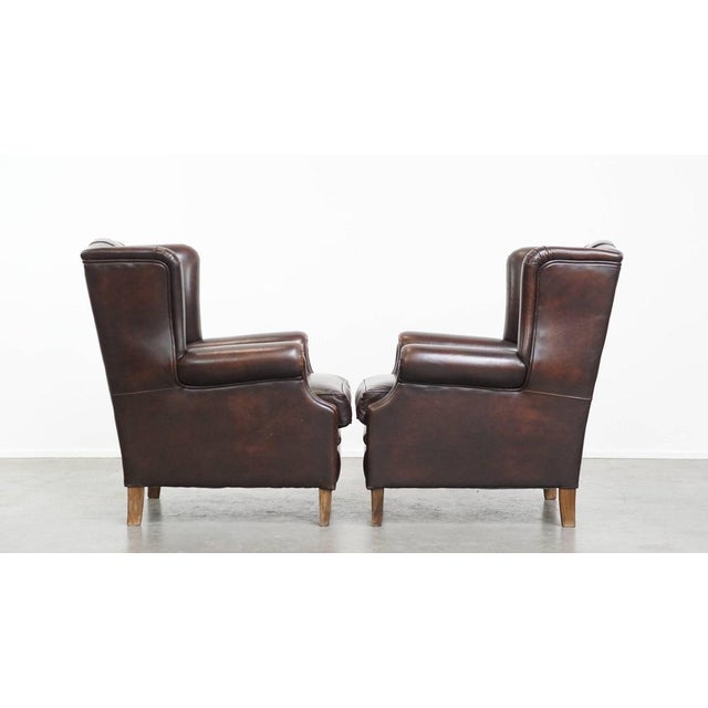 We are offering this comfortable and very attractive set of two English-style cowhide wing chairs with a luxurious finish....