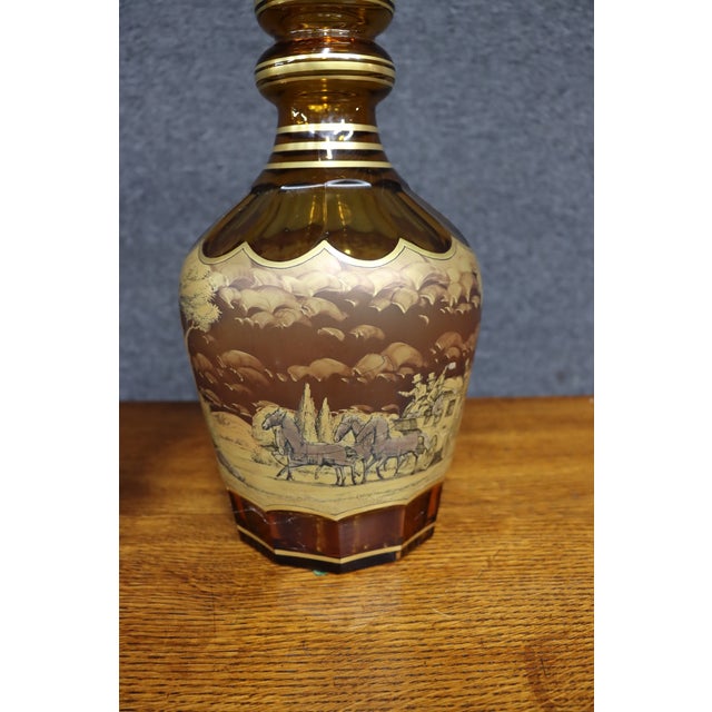 Set of three decorative Bohemian-style glass vessels in rich amber and brown tones with gold-tone banding and scenic...
