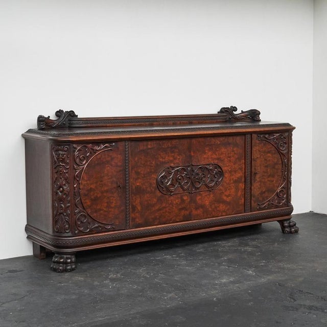 This is a beautiful and unusual sideboard in carved solid wood and walnut burl, made in Europe in the 1940s. The wonderful...