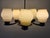 Ceiling lamp designed by Paavo Tynell, model 1376, brass frame, wooden center section, and glass shades. The lamp has...