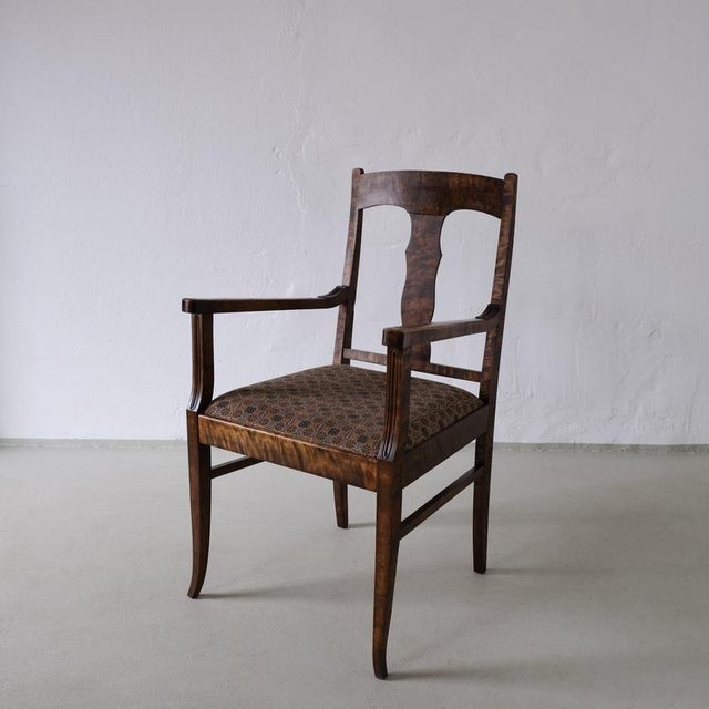 Pair of Biedermeier style armchairs in satin birch with brown upholstered seats. The chairs feature open backs, curved...