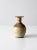 This is a vintage studio pottery vase. The hand-crafted bottleneck vase features a warm, cream glaze with rose pink...