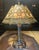 This antique Art Nouveau slag glass panel table lamp features an eight-sided octagonal design crafted with caramel, white,...