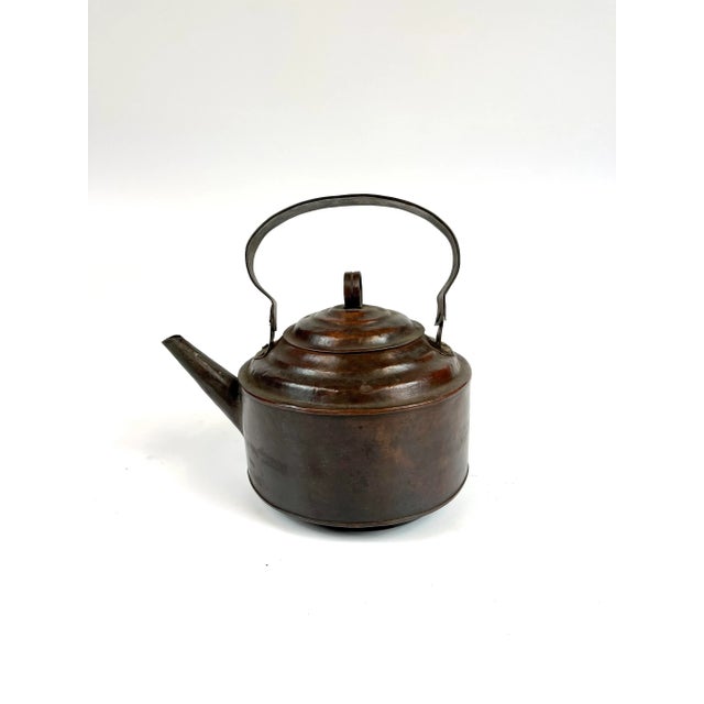 A light weight copper tea kettle with a handle.