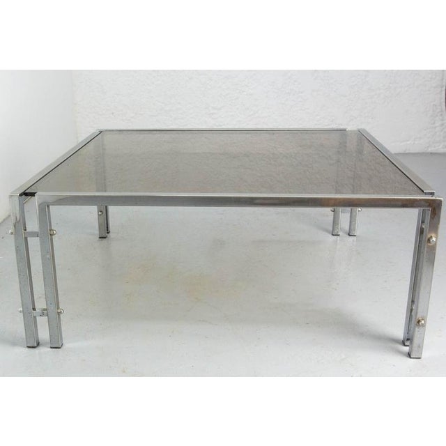 French coffee table with glass top and chrome structure. This design with it double legs is typical of the 1970's. In good...