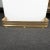 Perforated brass fireplace fender with cast animal foot and rope details.