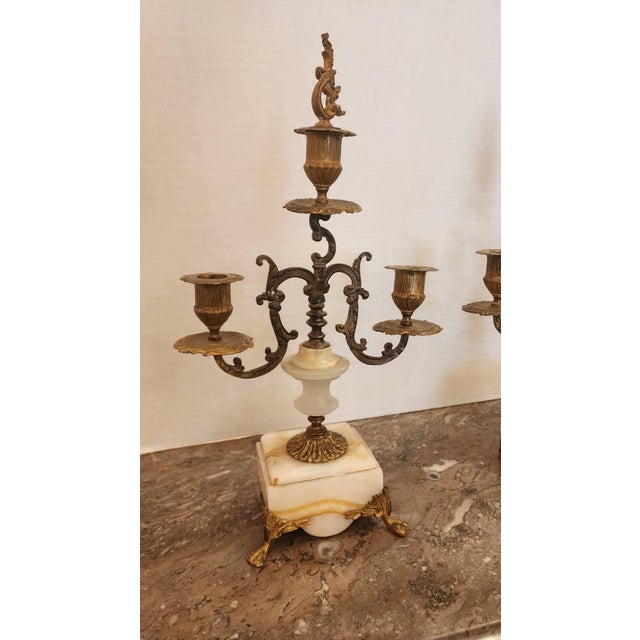 This listing features a pair of gilt bronze three-light candelabras that are Rococo-style and most likely originated from...