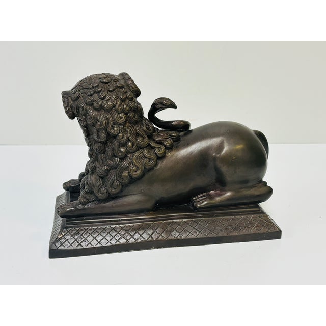 Stately, recumbent heavy Borghese lion sculpture with curled tail upwards and magnificent mane. In good condition - some...