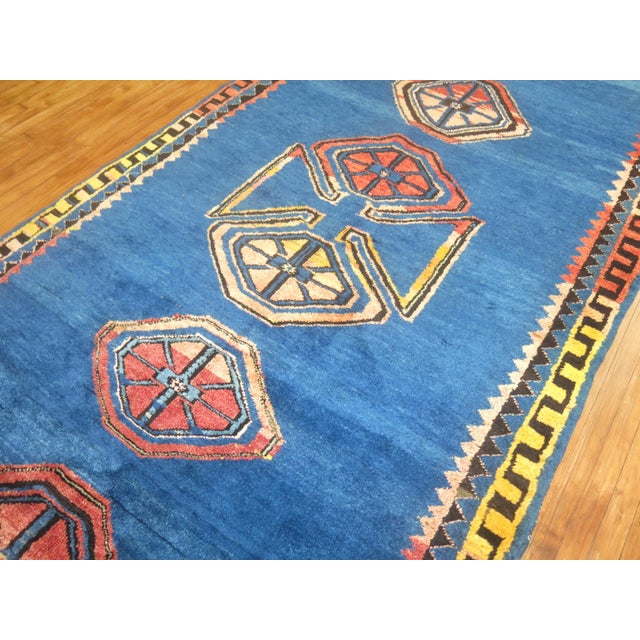 One of a kind mid-20th century handwoven Turkish rug with a folksy open palette design on a cobalt blue background. The...