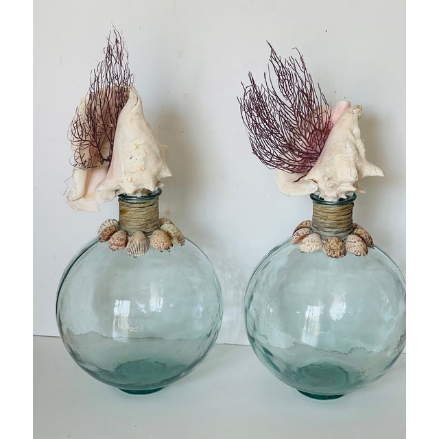 Gorgeous pair of large glass bottles encrusted with sea shells and topped with large conch shells with purple sea whip...