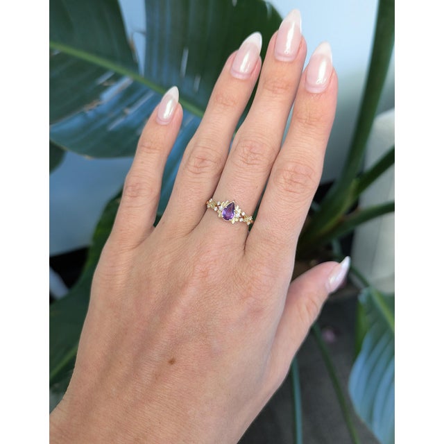 Rich purple sapphire, 8x4.5mm, set in solid 14K gold with earth-mined diamond accents. A stunning piece that combines...