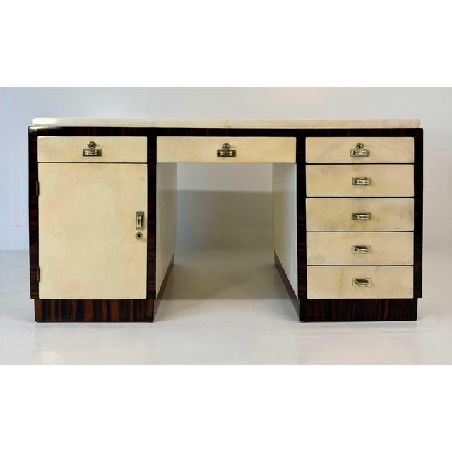 Elegant Italian Art Deco desk from the 1940s, crafted in parchment with contrasting dark exotic hardwood profiles and...
