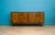 Four door sideboard in figured birch veneer with a walnut-effect finish, raised on tapered legs. Clean front with no...