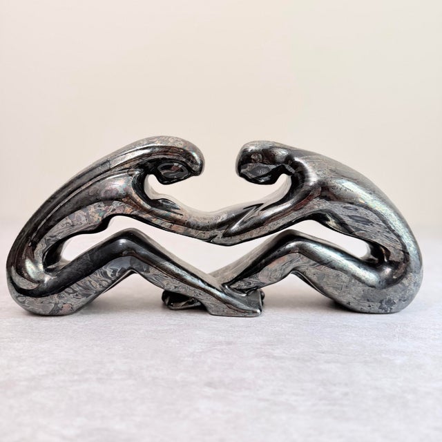 A bold Haeger abstract sculpture in the iconic black and silver marbleized glaze, depicting two interlocking figural forms...