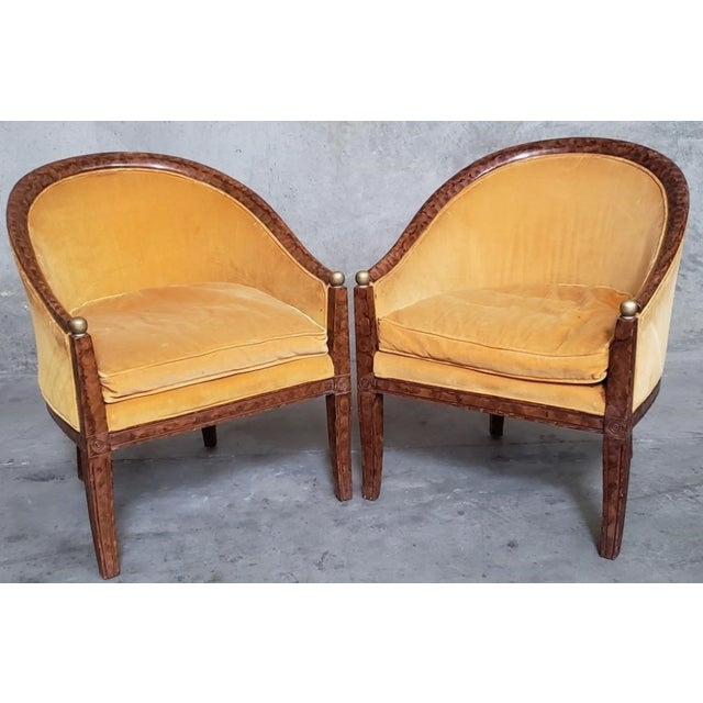 A striking pair of Art Deco barrel-back armchairs featuring an unusual faux tortoiseshell decorative finish and elegant...